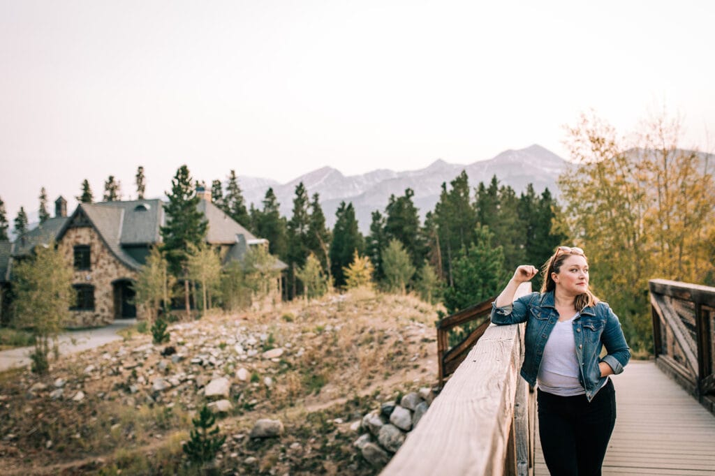 photo of woman with house and mountains in the background