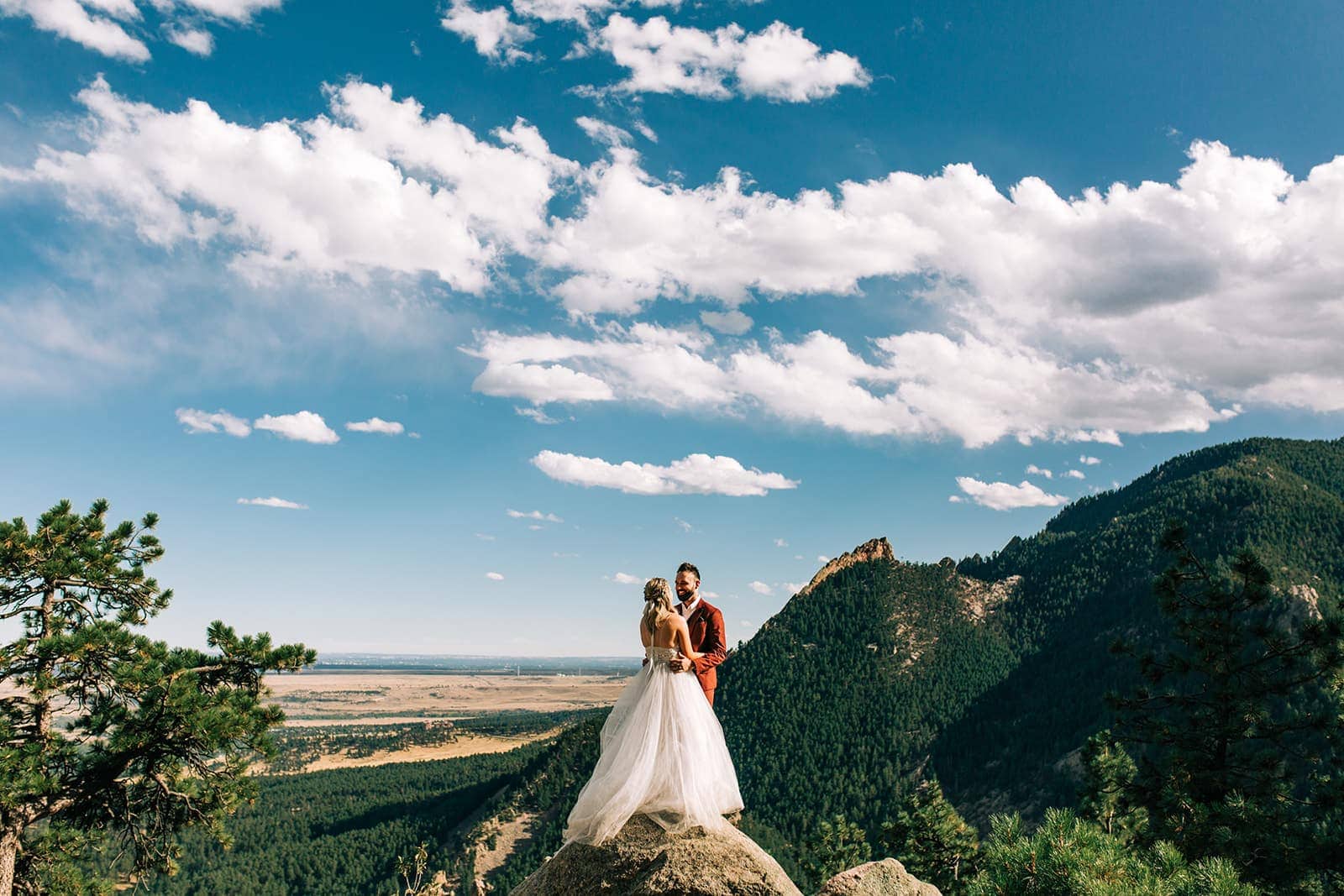 Photo of bride and groom at Sunrise Amphitheater with mountains in the background.