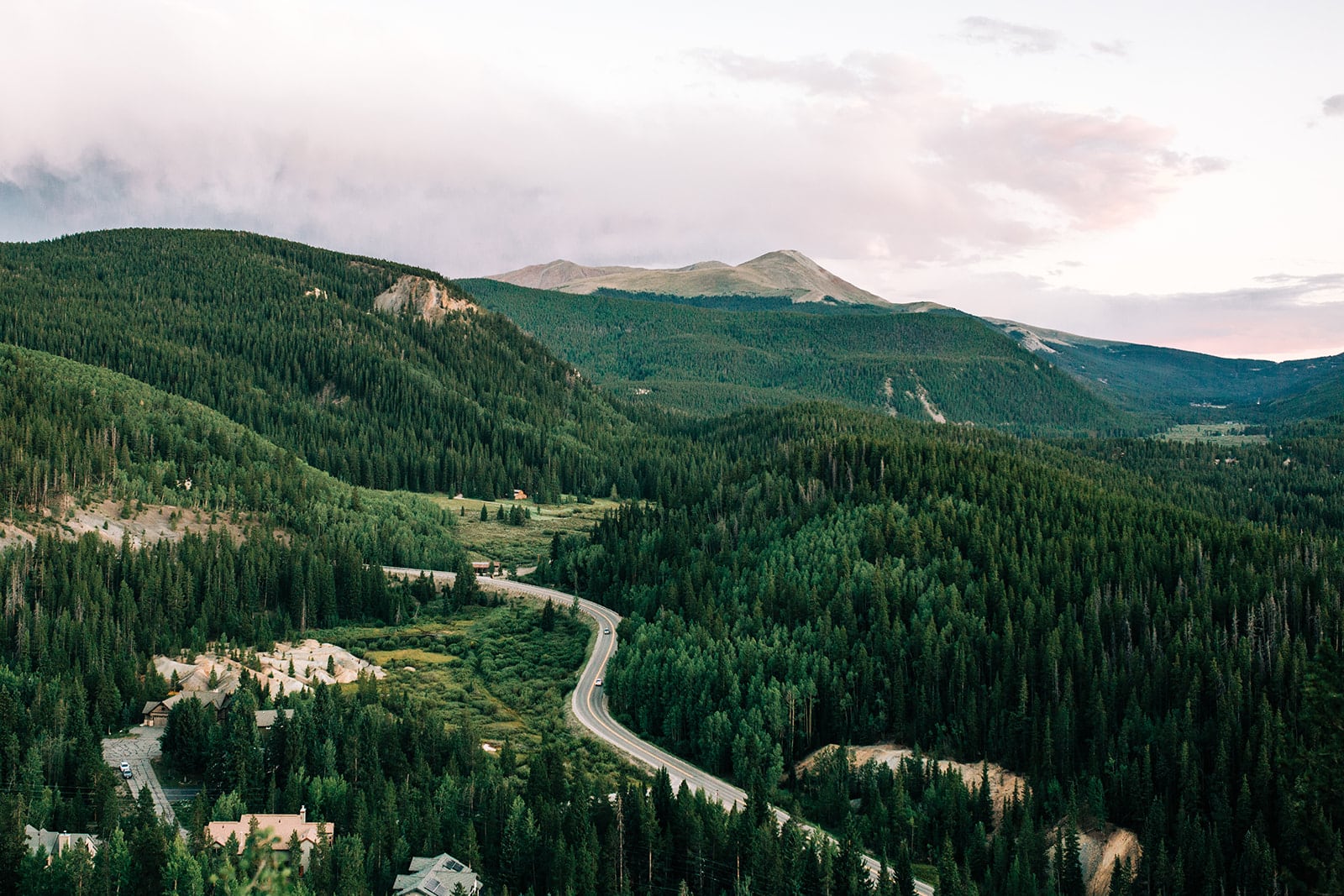 Photo of a mountain view in Breckenridge in the summer with green grass in a winding road